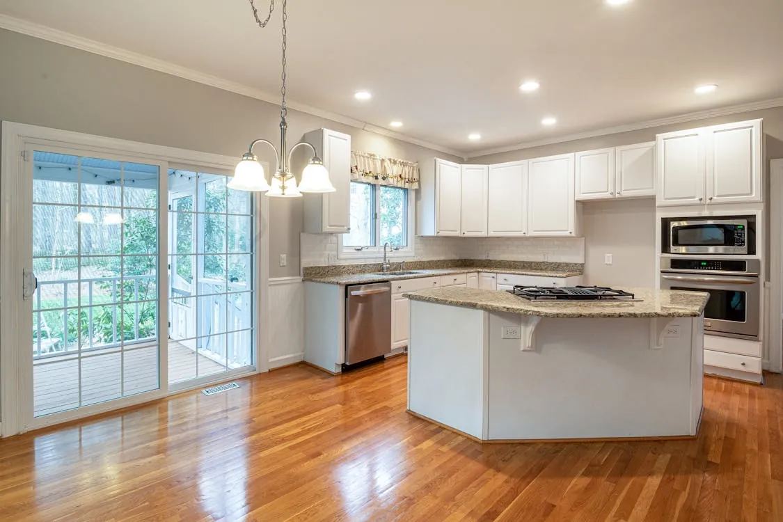 Modern kitchen with white cabinetry, island countertop, and sliding glass doors